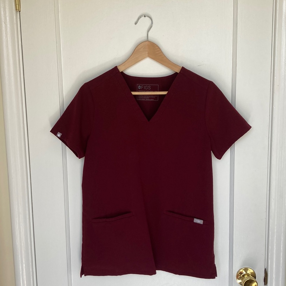 Women’s burgundy Casma 3-pocket scrub top. Size XS. Used.